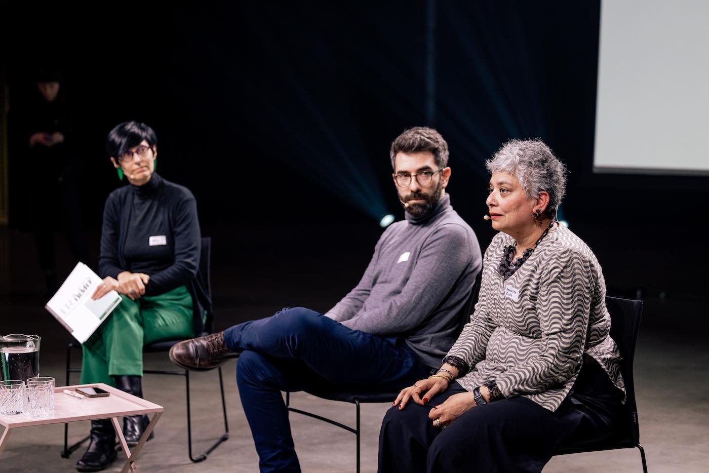 Three people sitting on a stage.