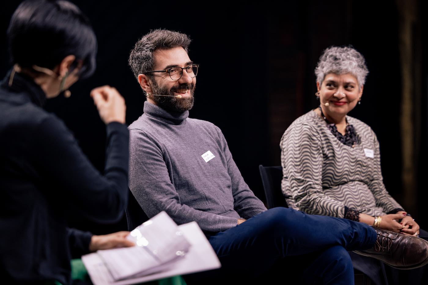 Three people on stage talking. 