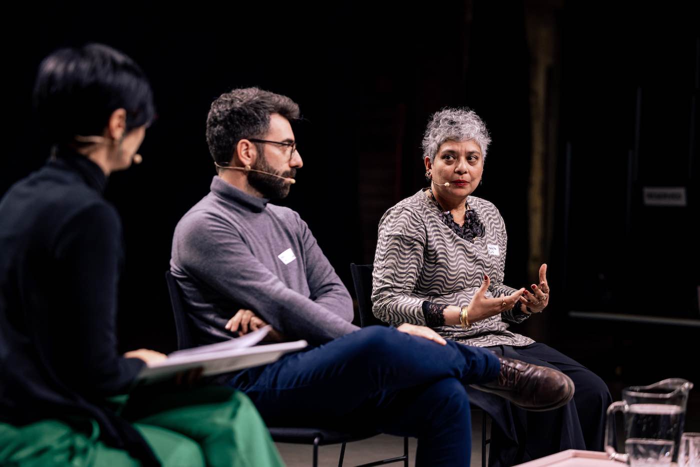 Three people sitting on a stage.