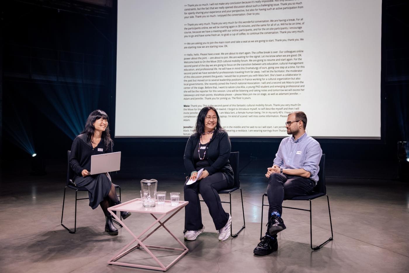 Three people sitting on a stage.