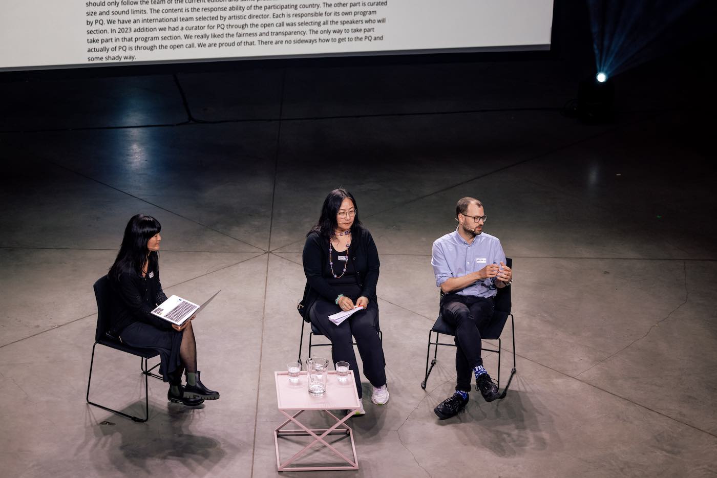Three people sitting on a stage.