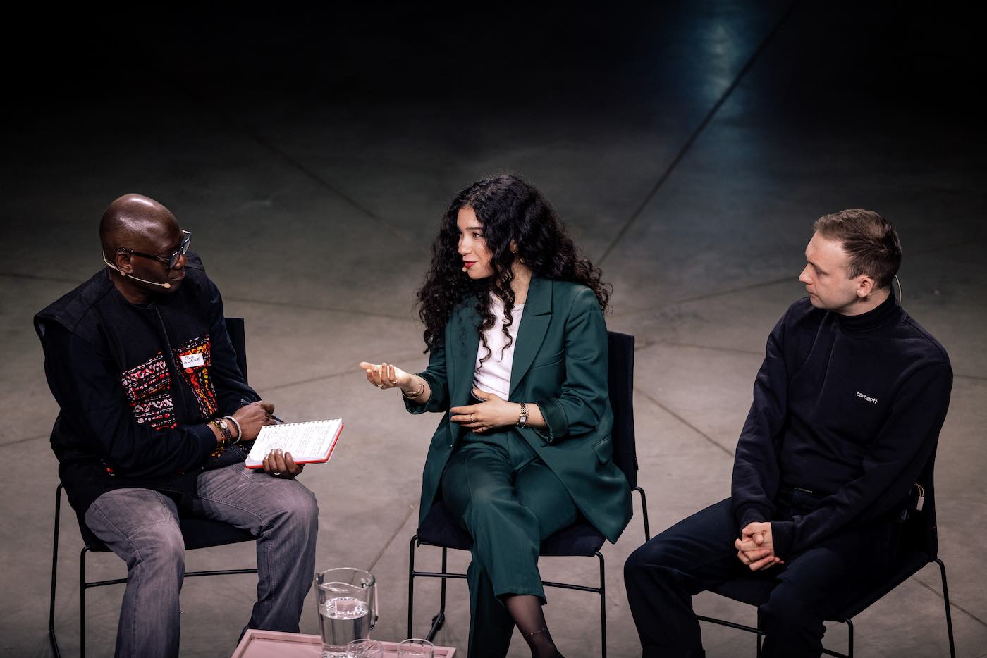Three people sitting on a stage.