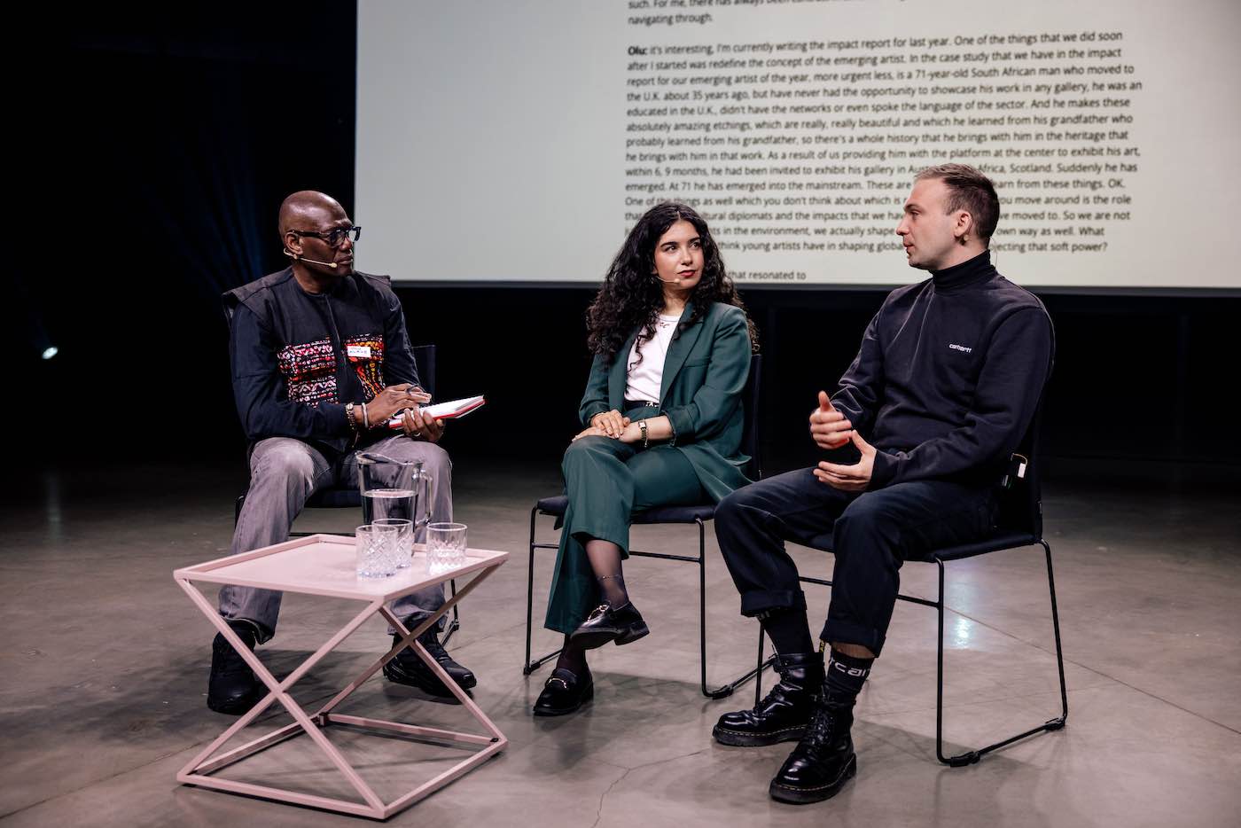 Three people sitting on a stage.
