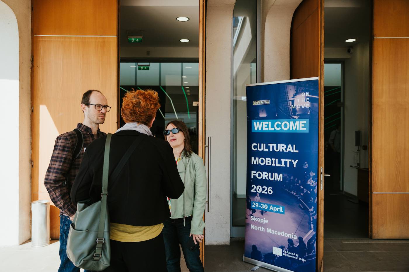 Three people standing in front of of the Forum poster.