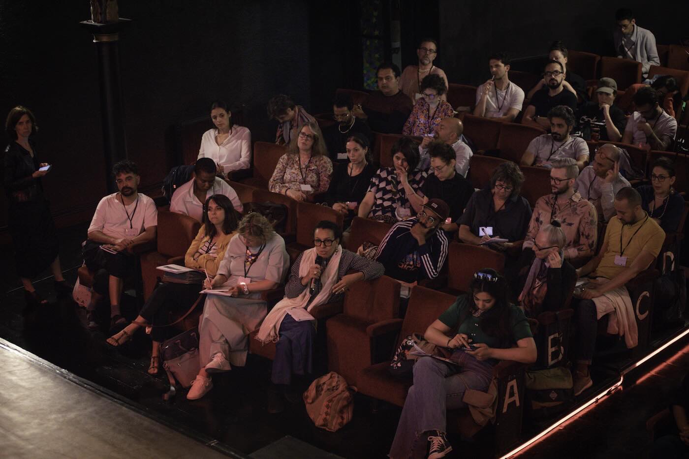 An audience listening in a theatre space. 