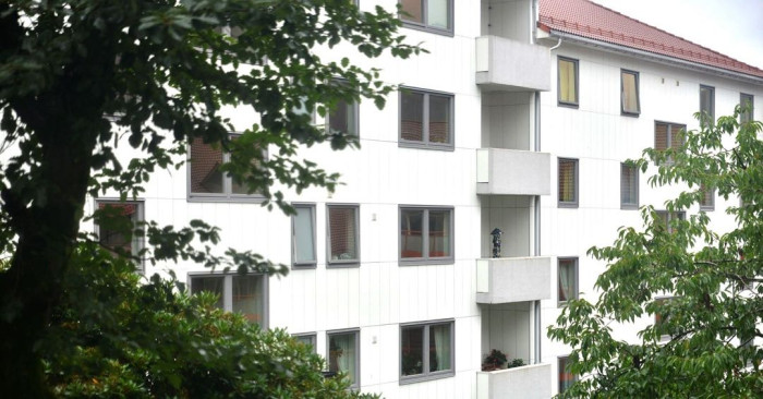 A multi-story white building with some trees. 