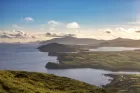 Fluffy clouds scud over rolling hilltops in this aerial view of Ireland's Dingle Peninsula.