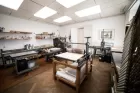 A print-making studio with big rollers and pressers at various desks.
