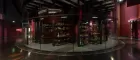 Interior of Musée du quai Branly – Jacques Chirac: lots of drums and musical instruments in glass cabinets, darkly lit.