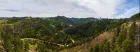 Wooded hills with a dirt road running through them. 