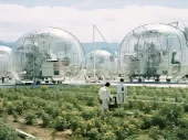 A simulated image of farm plants and people walking in white suits and several globes with machinery inside.