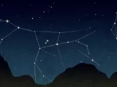 Stars linked with lines and an outline of a dark mountain. 