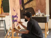 A person at an easel painting. 