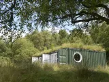 A small building in a forest environment. 