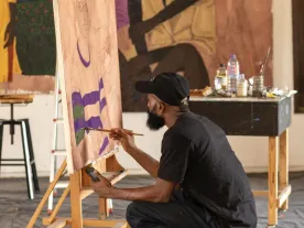 A person at an easel painting. 